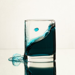 A splash of blue alcohol in a glass of whiskey