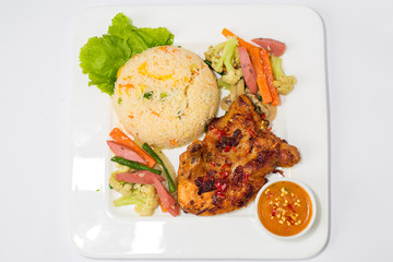 A plate of fried rice, hot chicken stake with sauce and mixed thai vegetabls. Top view.