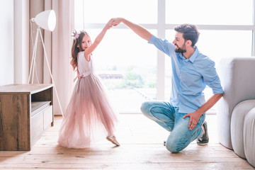 small girl and daddy dancing in living room together