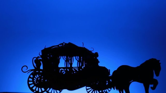 Black Silhouette Of A Horse Carriage Rotating On A Blue Background.
