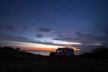 Fototapeta premium camping, mobile home on the beach, green grass, twilight