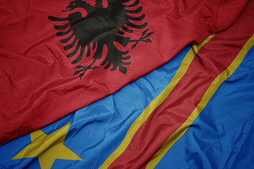 waving colorful flag of democratic republic of the congo and national flag of albania.