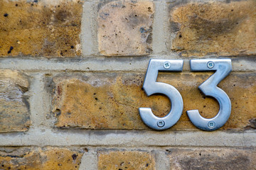 House number 53 on a brick wall