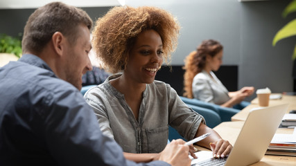 Smiling multiracial diverse colleagues working together at office.