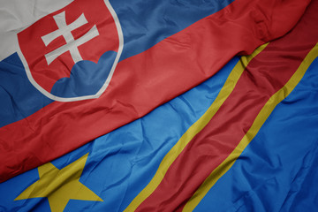 waving colorful flag of democratic republic of the congo and national flag of slovakia.