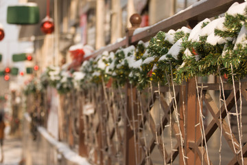 Decoration of wooden handrails Christmas tree twigs and luminous garlands and on the background of Christmas toys and lanterns..