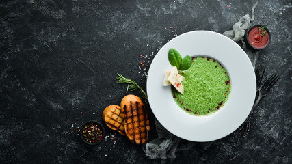 Spinach puree soup in a plate. Top view. Free copy space.
