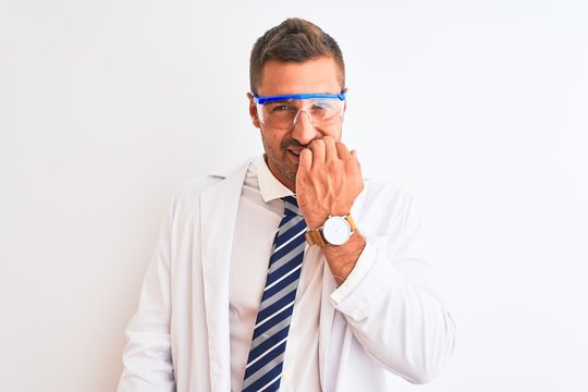 Young handsome scientist man wearing safety glasses over isolated background looking stressed and nervous with hands on mouth biting nails. Anxiety problem.