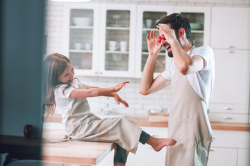 happy father and daughter having fun on the kitchen