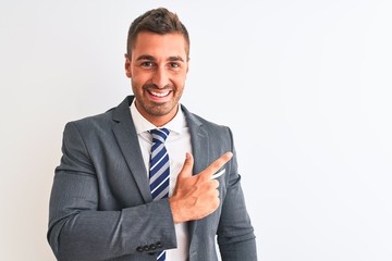 Young handsome business man wearing suit and tie over isolated background cheerful with a smile on face pointing with hand and finger up to the side with happy and natural expression