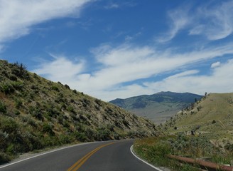 Scenic winding road at Yellowstone National Park on a beautiful day near the Gardiner exit in Montana.