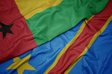 waving colorful flag of democratic republic of the congo and national flag of guinea bissau.
