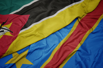 waving colorful flag of democratic republic of the congo and national flag of mozambique.