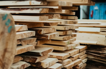 Folded boards and logs on construction site.
