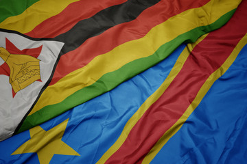 waving colorful flag of democratic republic of the congo and national flag of zimbabwe.
