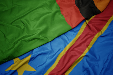 waving colorful flag of democratic republic of the congo and national flag of zambia.