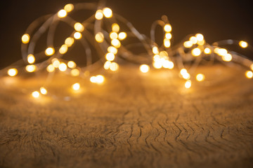 Defocus christmas lights on wooden background. selective focus on wood planks .