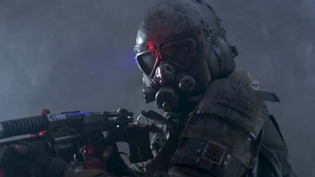 Post apocalypse soldier is aiming from his weapon, while posing for camera man.