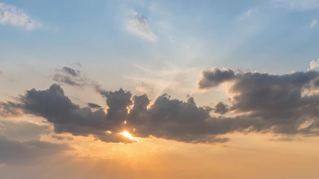 Cloudscape timelapse of sunset sky clouds with nice blue and yellow colors and sunlight through clouds. Sunset sky clouds. Sunset sky background. Beautiful clouds in the sky with sunbeam at sunset