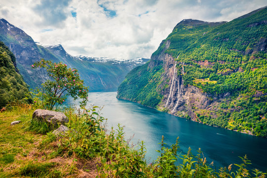 Sublime summer scene of Sunnylvsfjorden fjord, Geiranger village location, western Norway. Beautiful morning view of famous Seven Sisters waterfalls. Beauty of nature concept background.