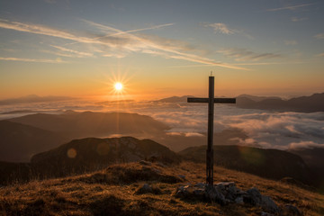 Sunrise with cross on top of a mountain Ogradi, Slovenia