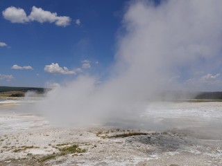 Fototapeta na wymiar Close up of steam rising from the Clepsydra Geyser at the Lower Geyser Basin, Yellowstone National Park.