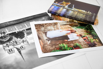 Photography canvas prints on white wooden background. Wedding and travel photos printed on glossy synthetic canvas