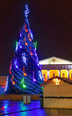 Night view of the Christmas tree at the Town Hall square in Vilnius, Lithuania. Winter. Street and holiday fair in European city Advent Decoration with Craft Items on Bazaar