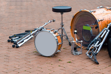 Dismantled drum kit and chair in  square after concert. Front view.