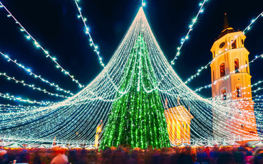 People at Christmas market and Xmas tree with decoration at Cathedral Square in Vilnius in...
