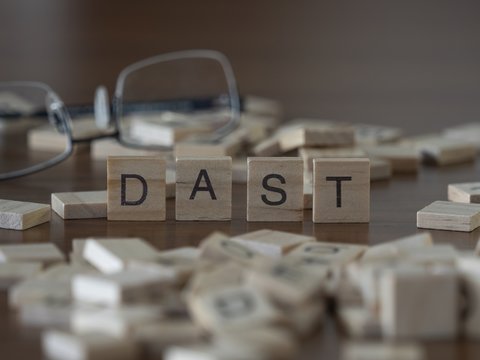 Teh acronym DAST for Dynamic Application Security Testing concept represented by wooden letter tiles