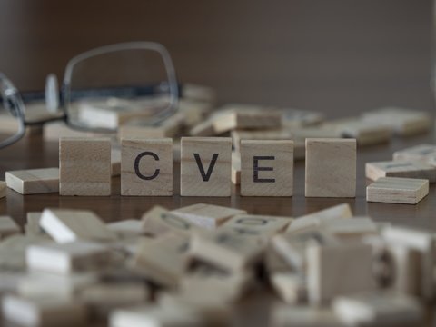 The acronym CVE for Common Vulnerabilities and Exposures concept represented by wooden letter tiles