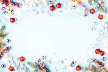 Christmas composition with fir branches, red baubles and decorations on blue background. Flat lay, New Year frame.