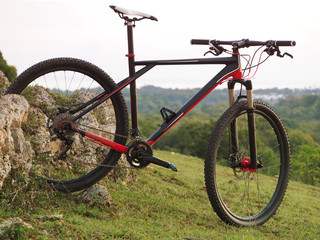 Fototapeta premium Mountain bike on the top of a hill. Sunrise Morning. Green nature landscape view of top the hill with tropical forest.