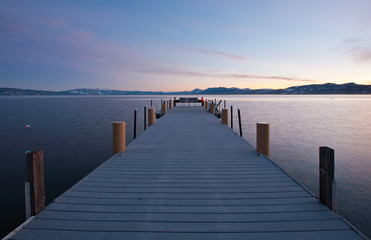 A pier out in a lake at sunset
