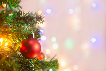 Christmas decoration. Hanging red balls on pine branches Christmas tree garland and ornaments over abstract bokeh background with copy space.