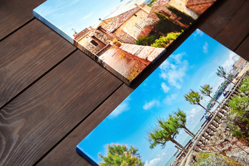 Canvas photo prints lying on a wooden table. Sample of gallery wrapping method of canvas stretching on stretcher bar. Side view of colorful photographs printed on glossy synthetic canvas