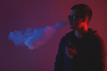 Vaping man with vaporizer and a cloud of vapor