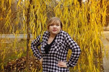 girl in a plaid shirt on a background of autumn leaves