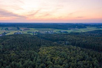 Dorf umgeben von Wald im Abendrot