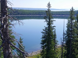 Medium wide shot of Yellowstone Lake from the top, with pine trees along the bank, Yellowstone National Park, Wyoming.
