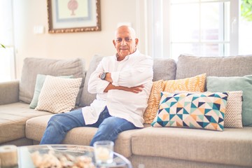 Obraz premium Senior handsome man smiling happy and confident. Sitting on the sofa relaxed at home