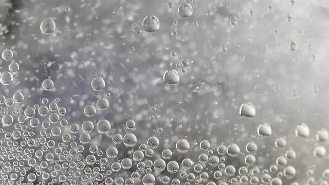 Boiling water. Air bubbles float in a liquid. Black-white texture.