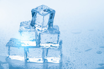 Ice cubes square with drops water clean on blue background