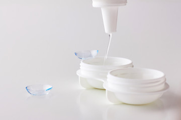 Contact lenses, case and bottle with solution on white background. Eye health and care, eyesight...