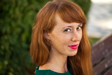 Fototapeta premium Portrait of a young red-haired girl with freckles