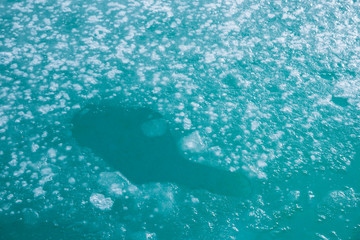 swimming pool in winter with swimming ice on the water surface