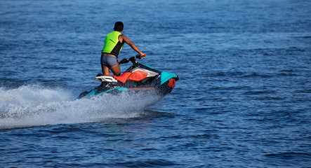 A Man on Jet Ski with much splashes. Water Sports. Vacation Concept.