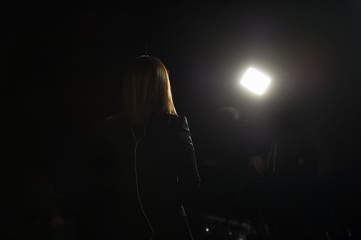 Journalist making a live broadcast in front of a spotlight