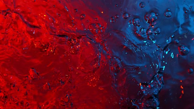 Super slow motion of splashing water illuminated by neon lights. Filmed on very high speed camera, 1000 fps.